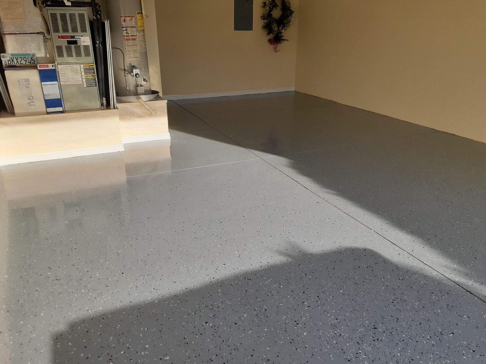 A garage with a gray floor and a wreath on the wall