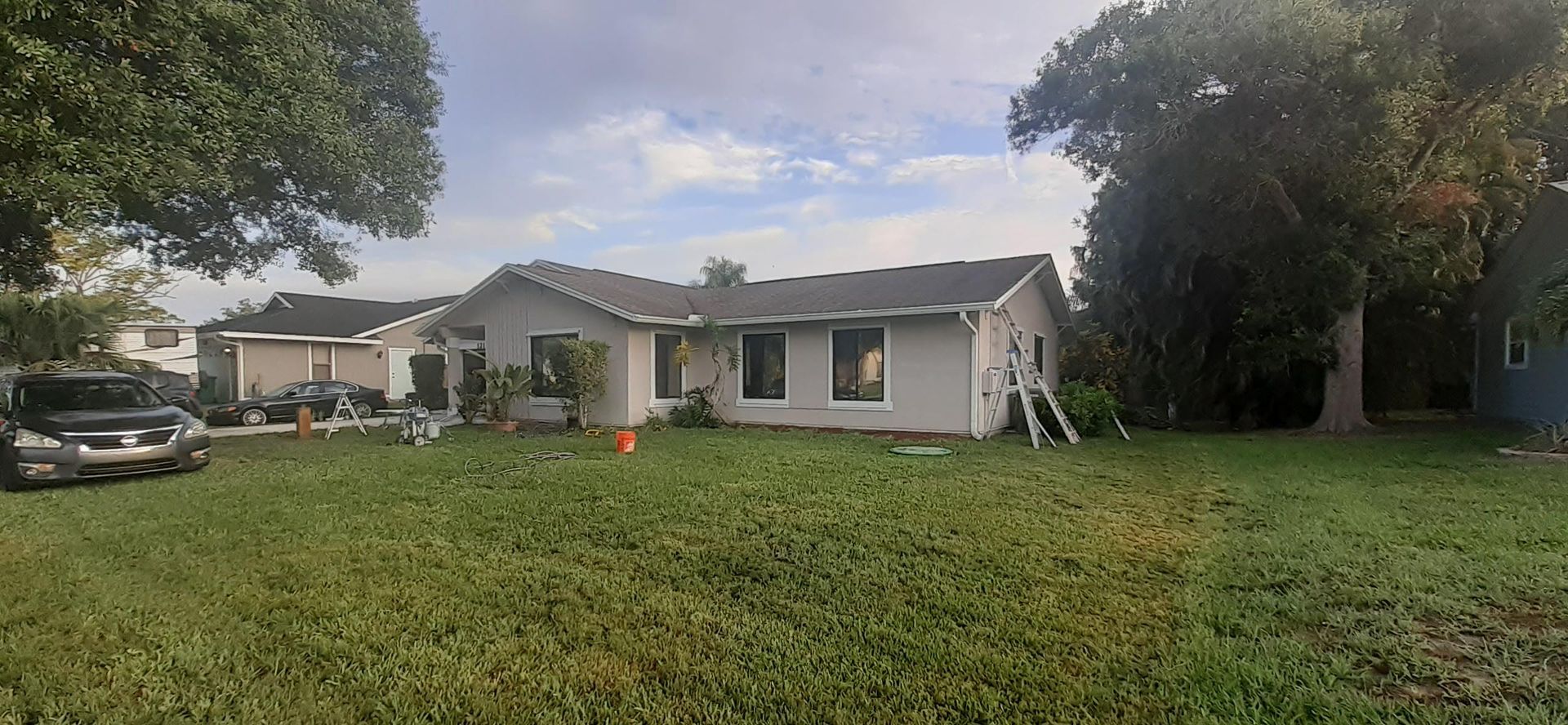 A white house with a car parked in front of it.