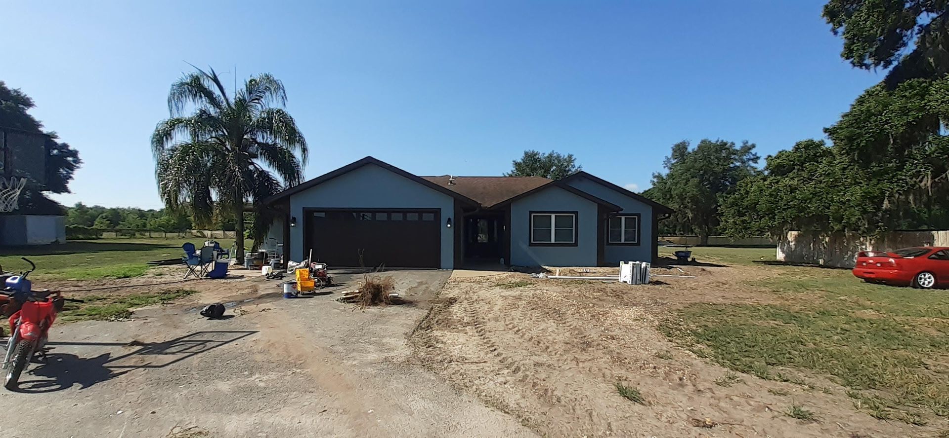 A house with a red car parked in front of it.