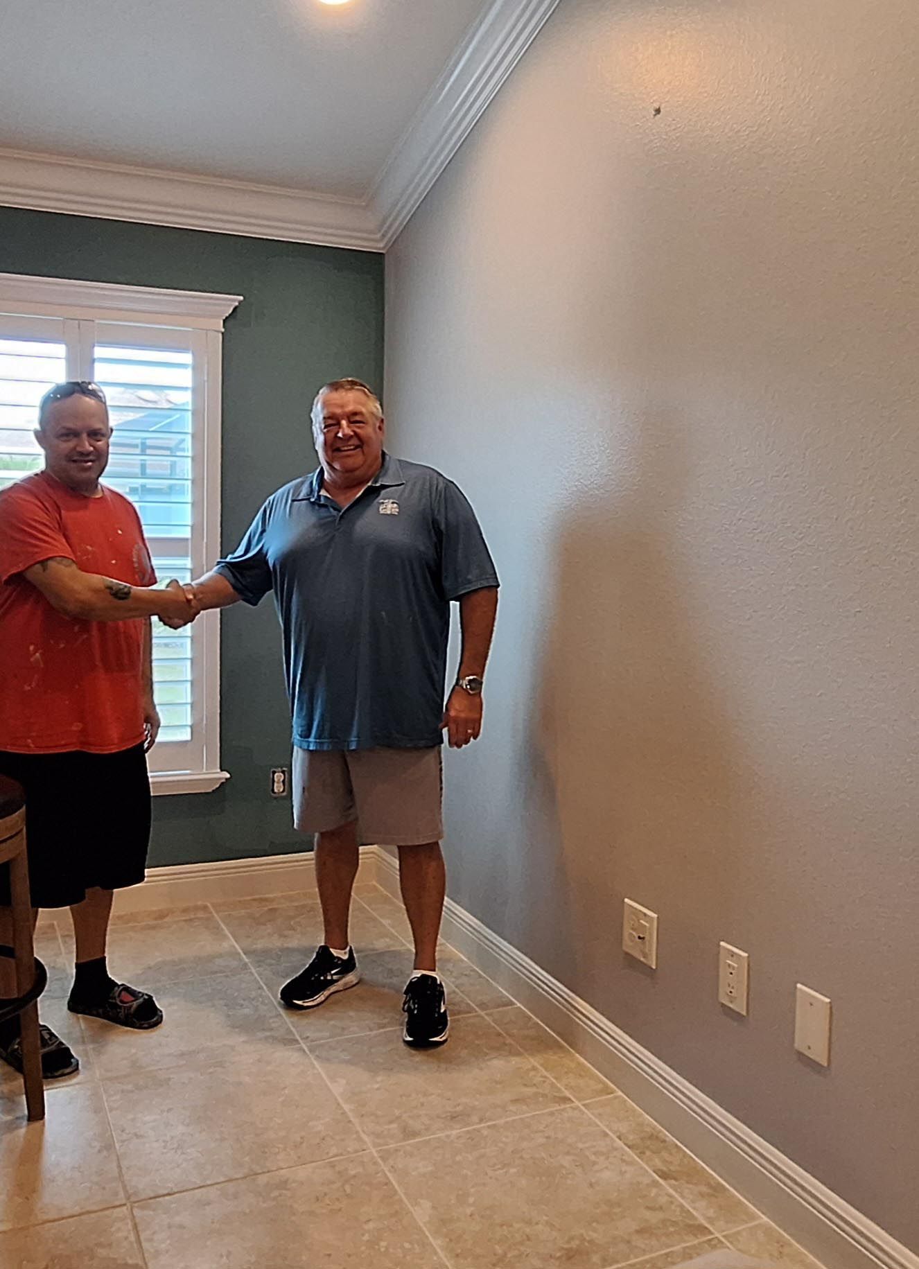 Two men are shaking hands in a room.