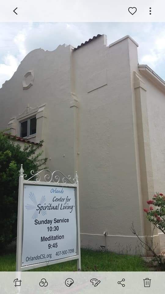 A white building with a sign in front of it.