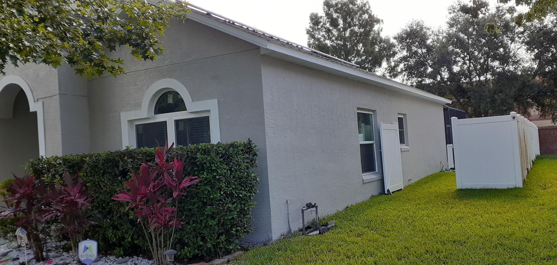 A white house with a white fence in front of it.