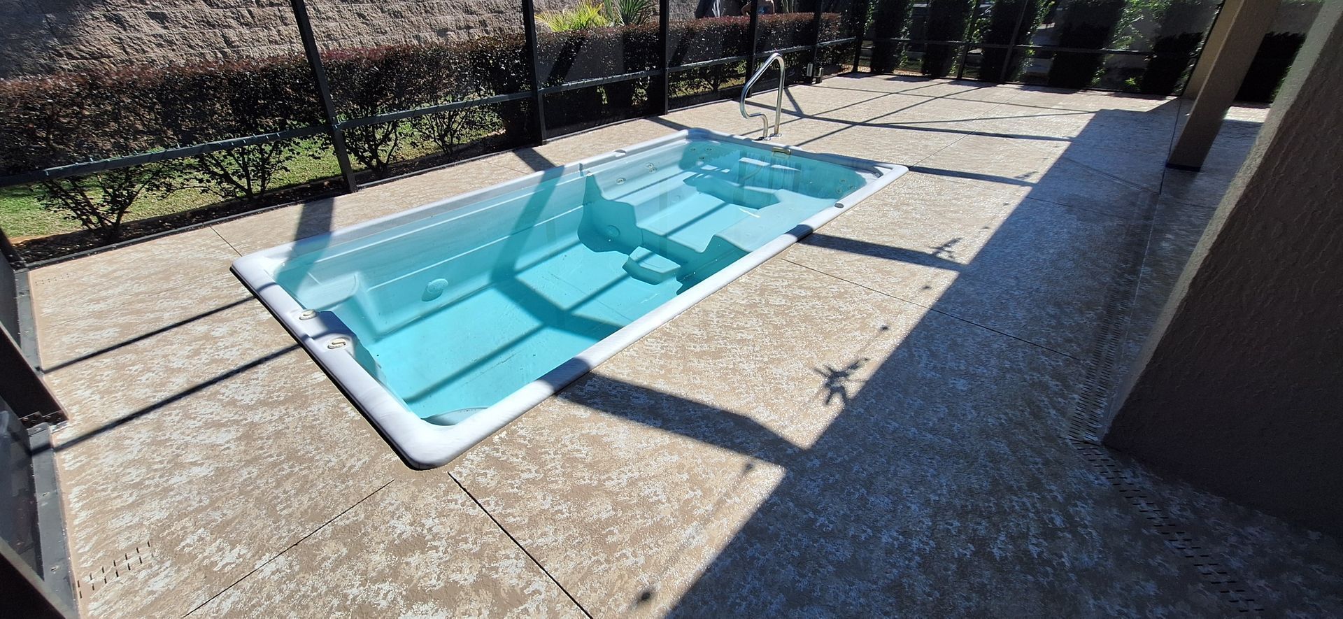 A small swimming pool is sitting on top of a concrete patio.