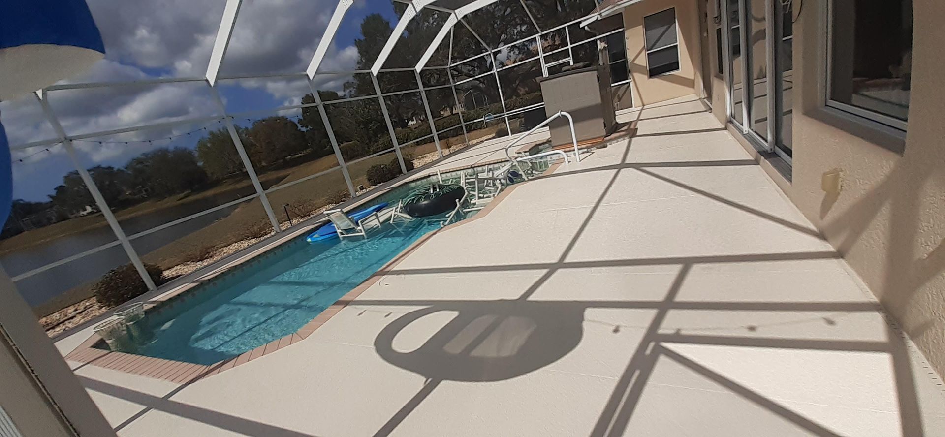 There is a swimming pool in the backyard of a house.