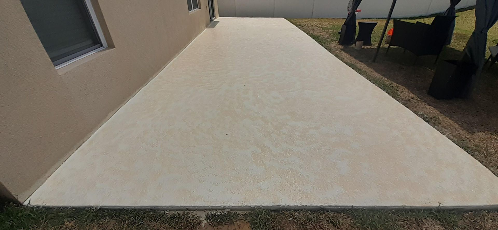 A concrete walkway leading to the side of a house.