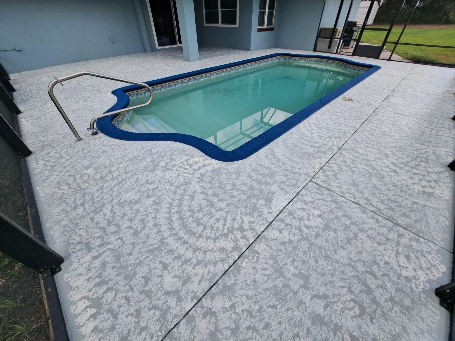 A swimming pool is sitting on top of a concrete deck.