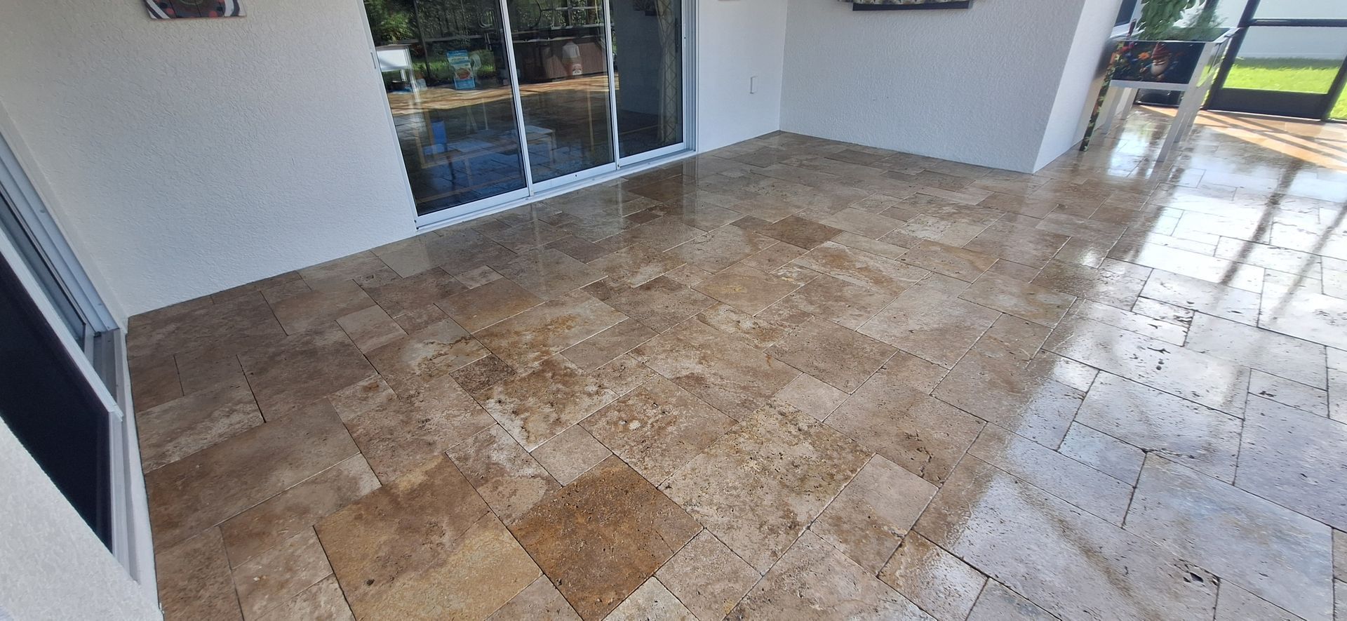 A patio with a tiled floor and sliding glass doors.