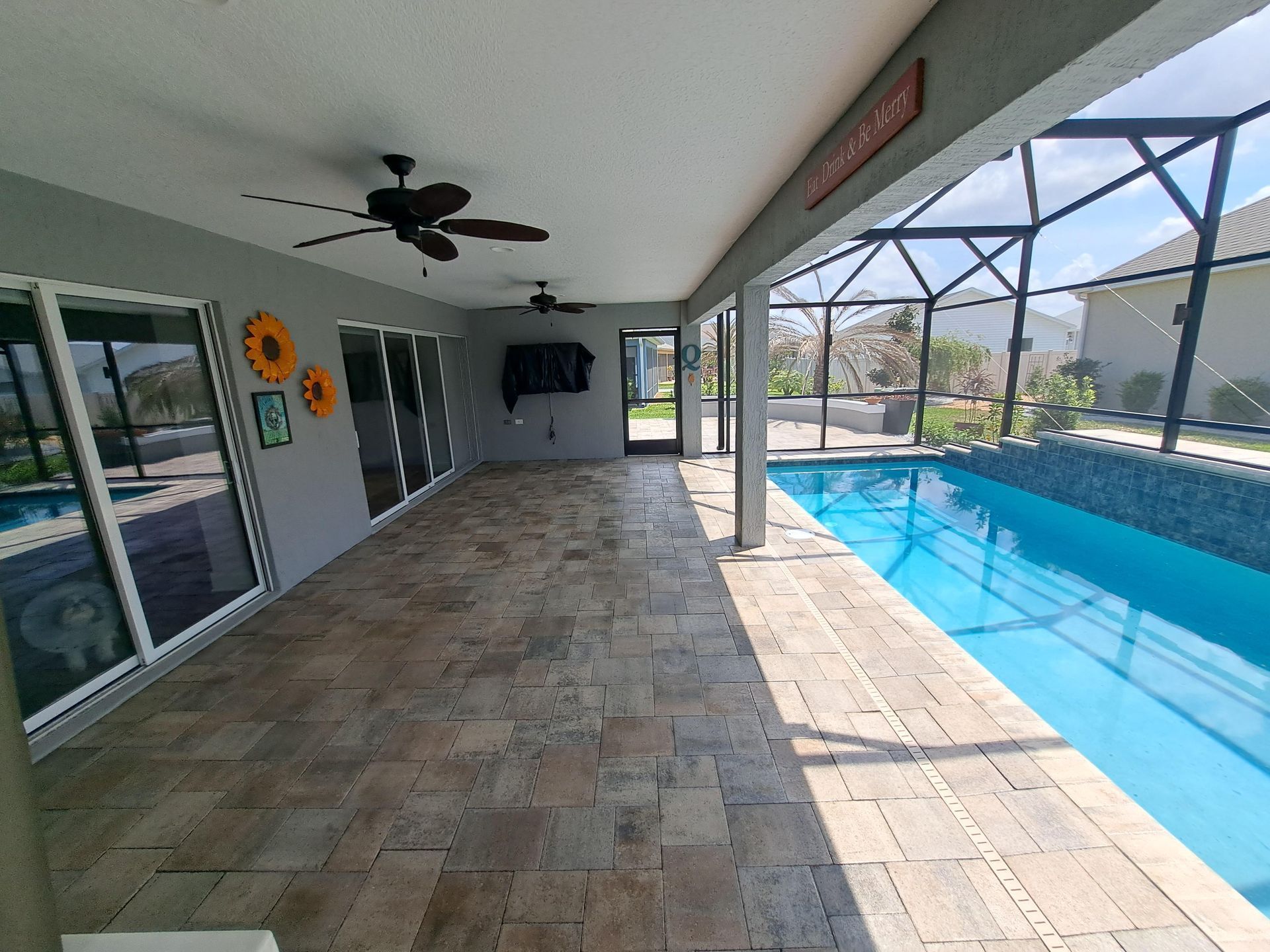 There is a large swimming pool in the backyard of a house.