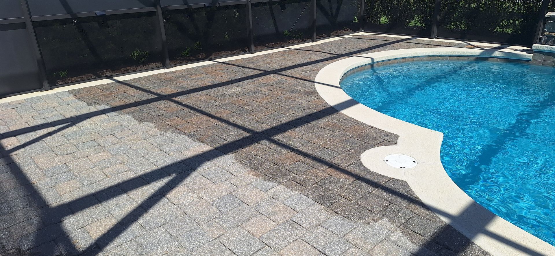 A swimming pool with a patio in front of it.
