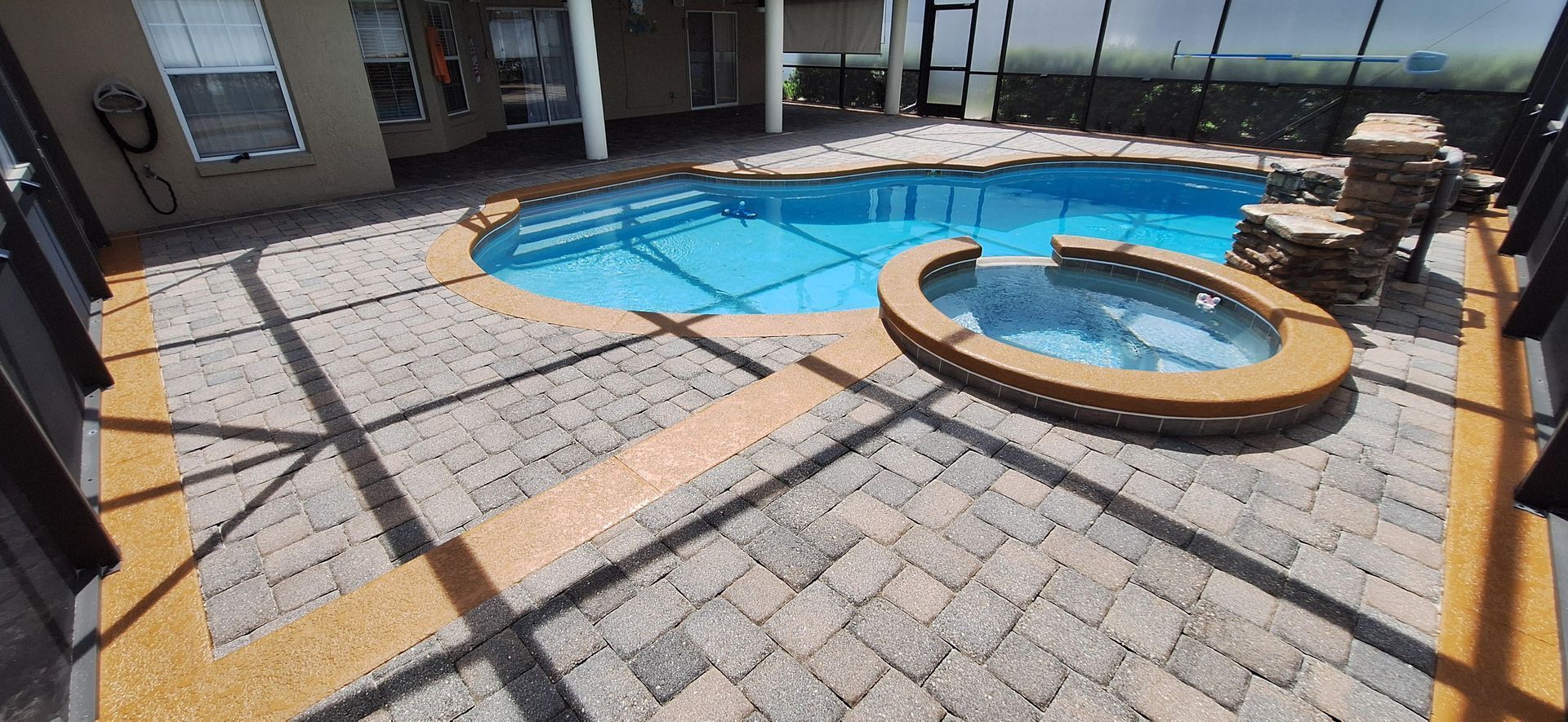 A large swimming pool with a hot tub in the middle of it.