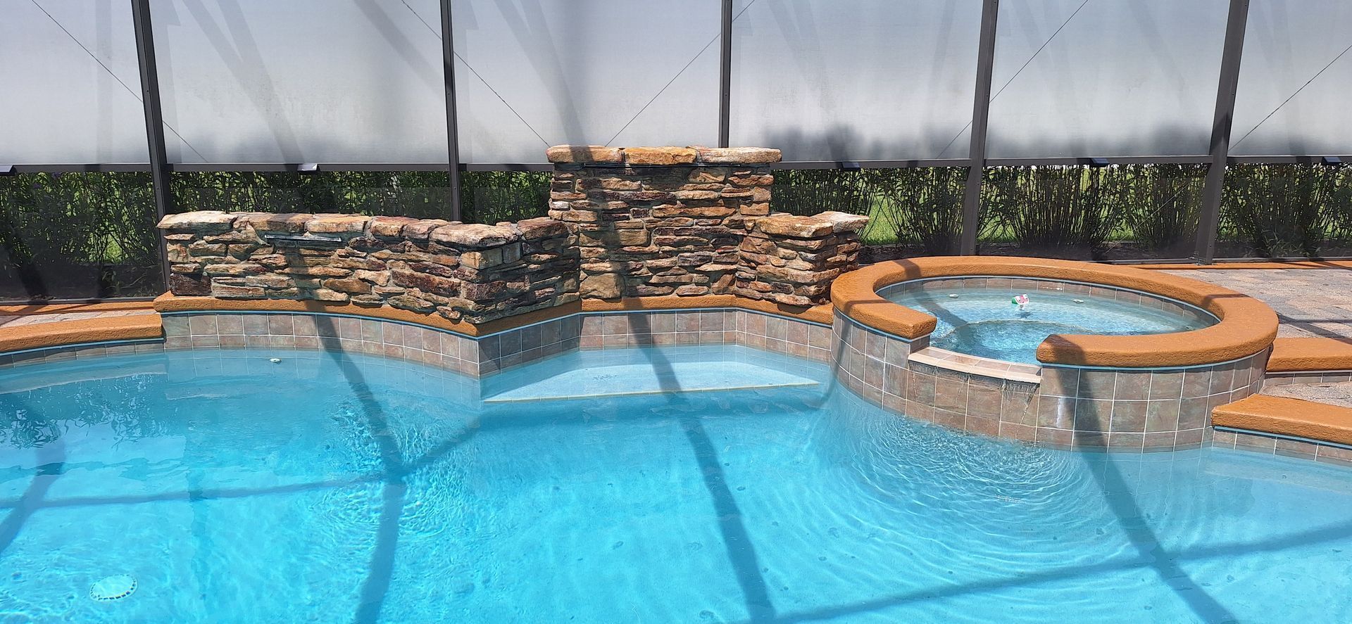 A large swimming pool with a hot tub in the middle of it.