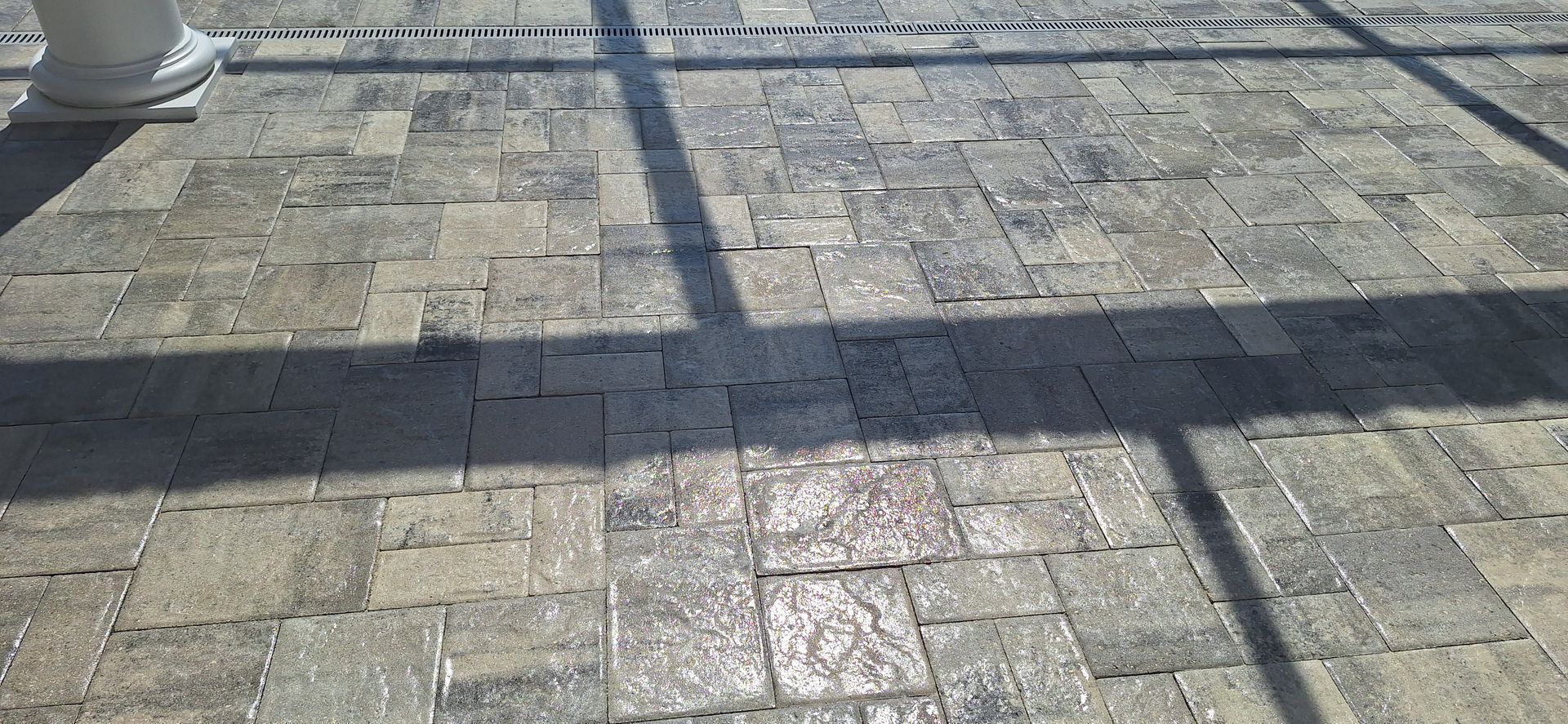 A person 's shadow is cast on a brick floor.