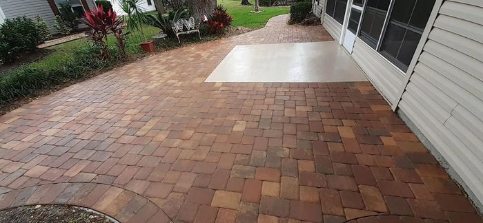 A brick walkway leading to a screened in porch
