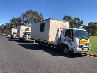 Truck driver standing by container truck — Tow in Dubbo, NSW