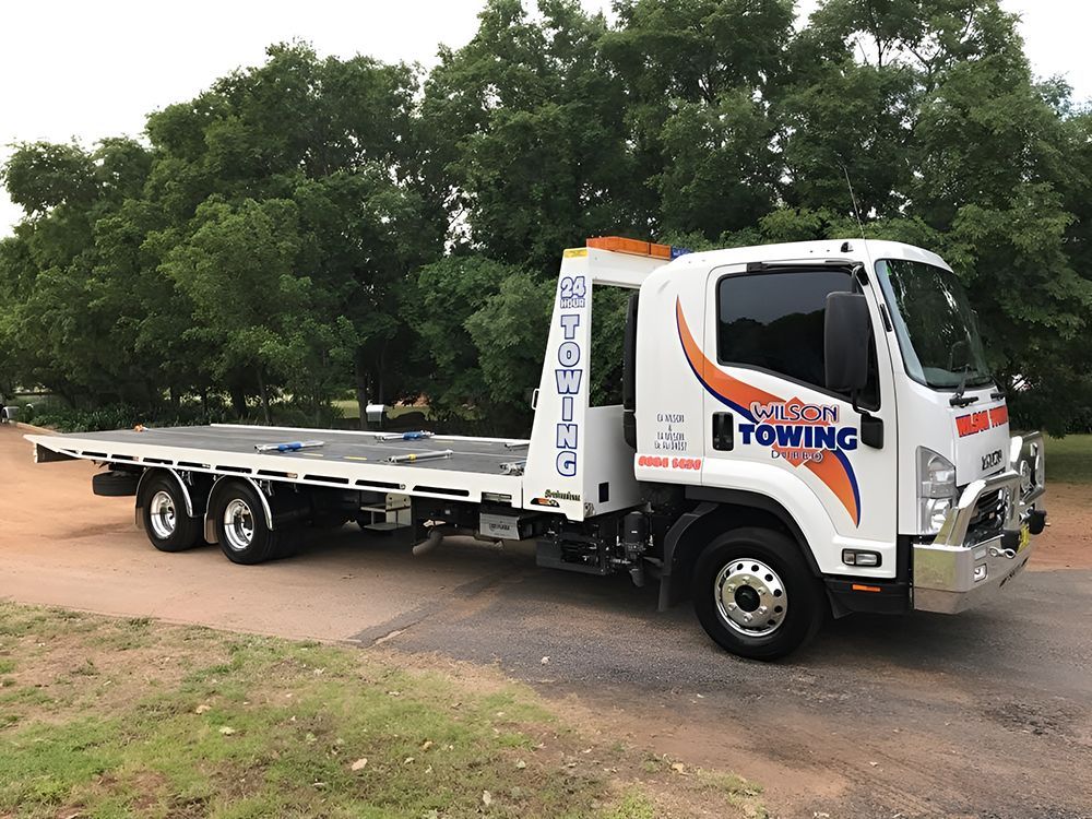 White Isuzu Flatbed Tow Truck with Orange and Blue Logo — Tow in Dubbo, NSW