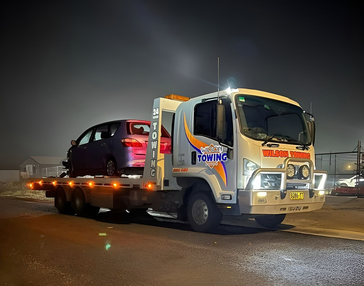 Tow Truck Carrying A Purple Car At Night