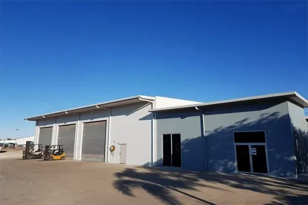 Exterior of a Large Gray Industrial Building With Garage Doors— Griffin Distributors In  Mount St John, QLD