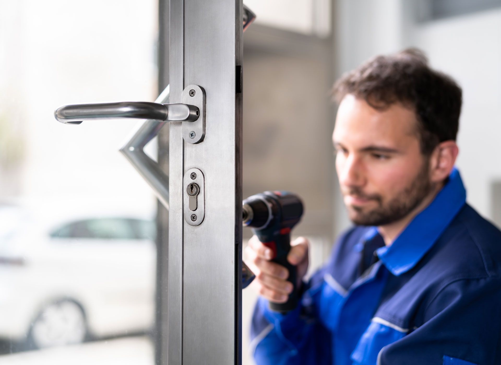 A man is fixing a door with a drill.