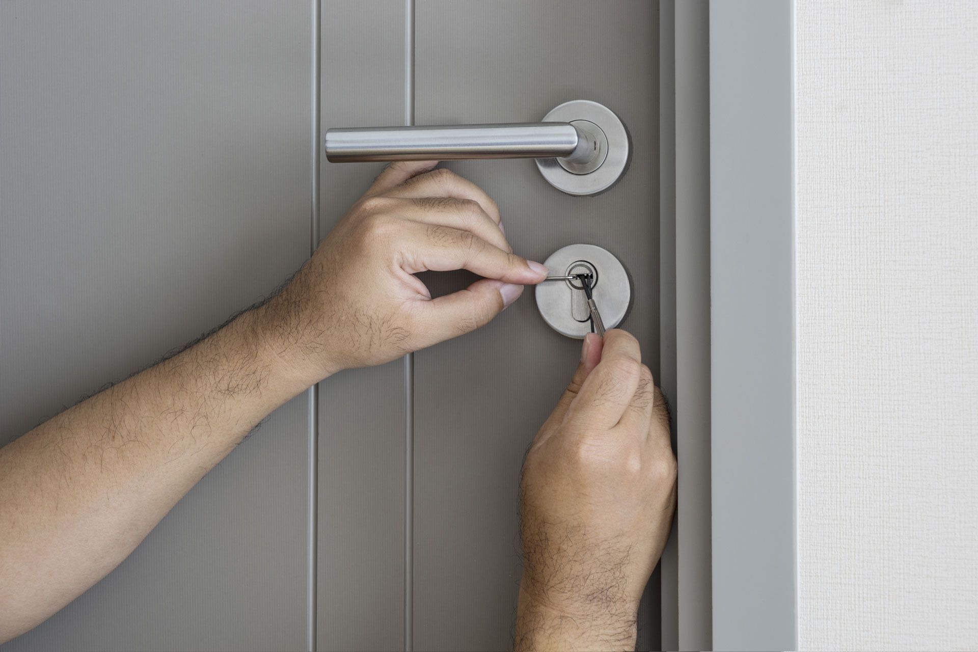 A person is opening a door with a key.