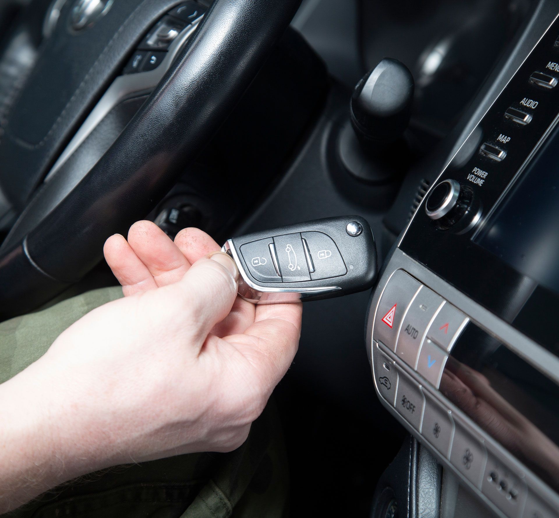 A person is holding a car key in their hand.