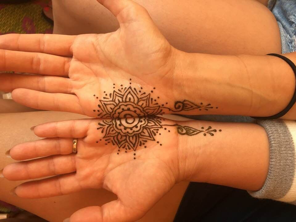A woman has a henna tattoo on her hand and wrist