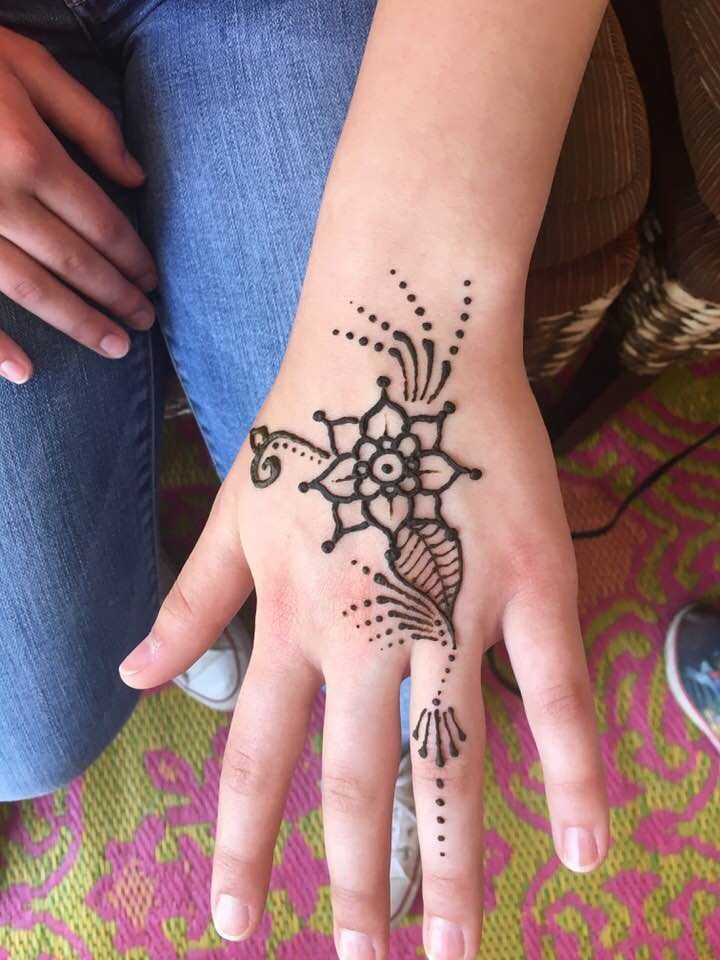 A woman 's hand with a henna tattoo on it