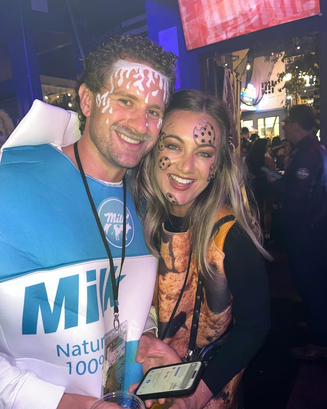 A man and a woman are posing for a picture in a milk carton costume.