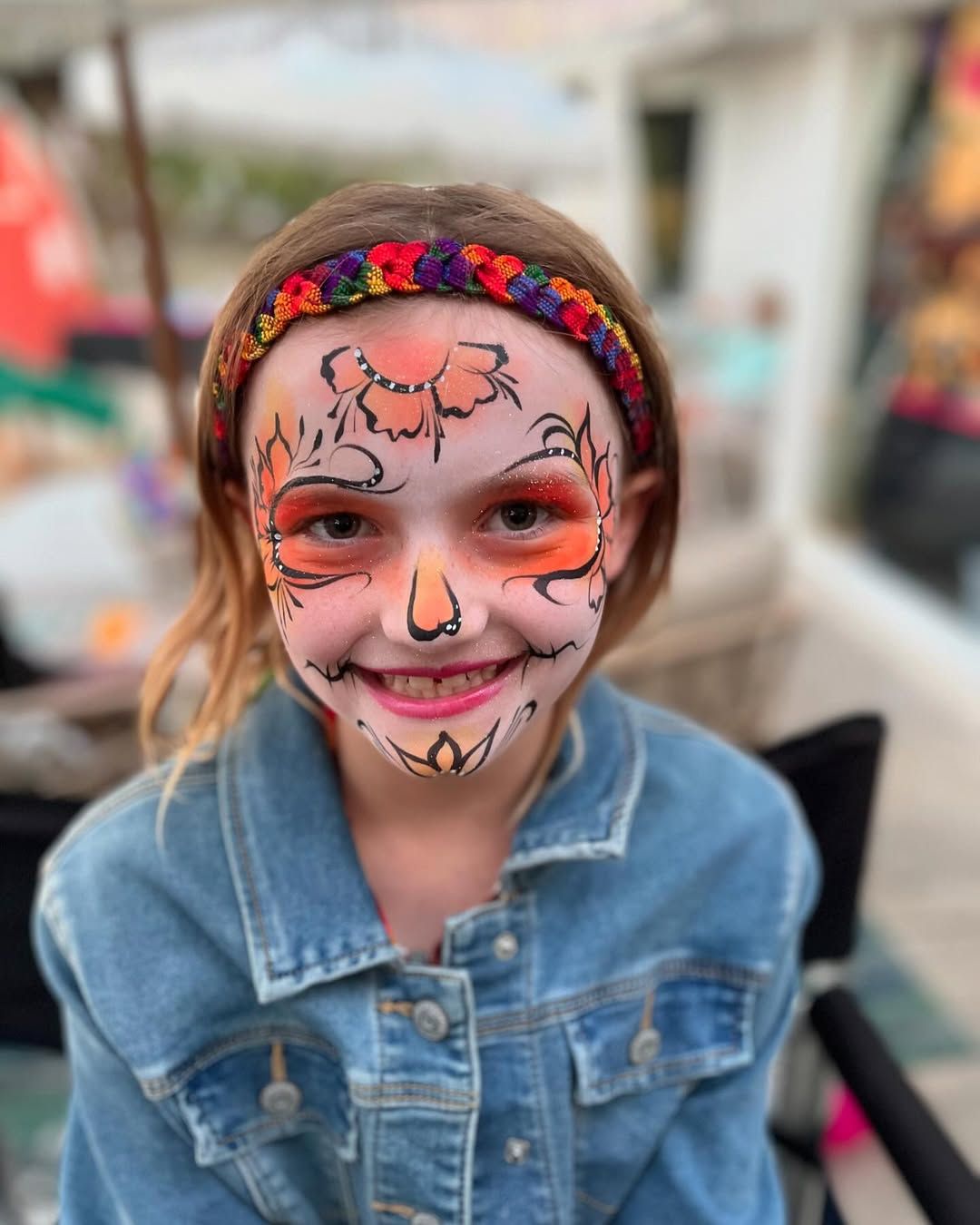 A little girl with her face painted like a tiger
