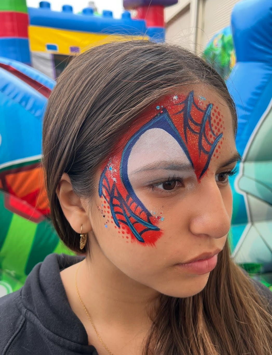 A woman has a spider man face painted on her face.