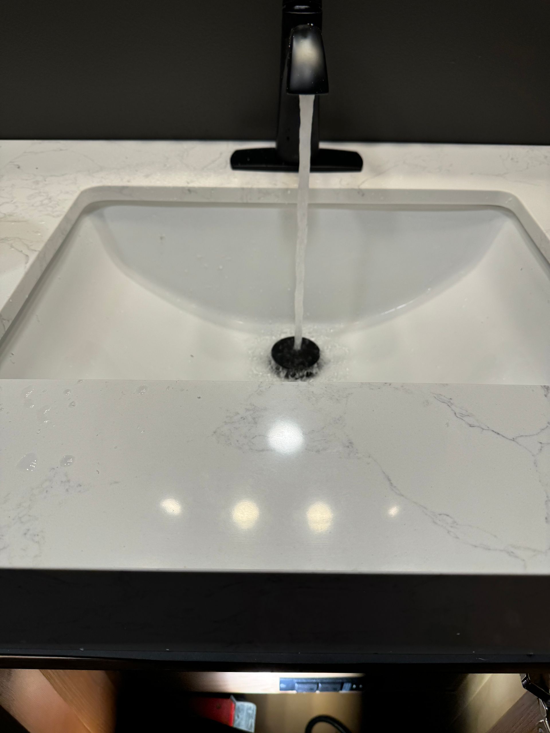 A bathroom sink with water coming out of the faucet.