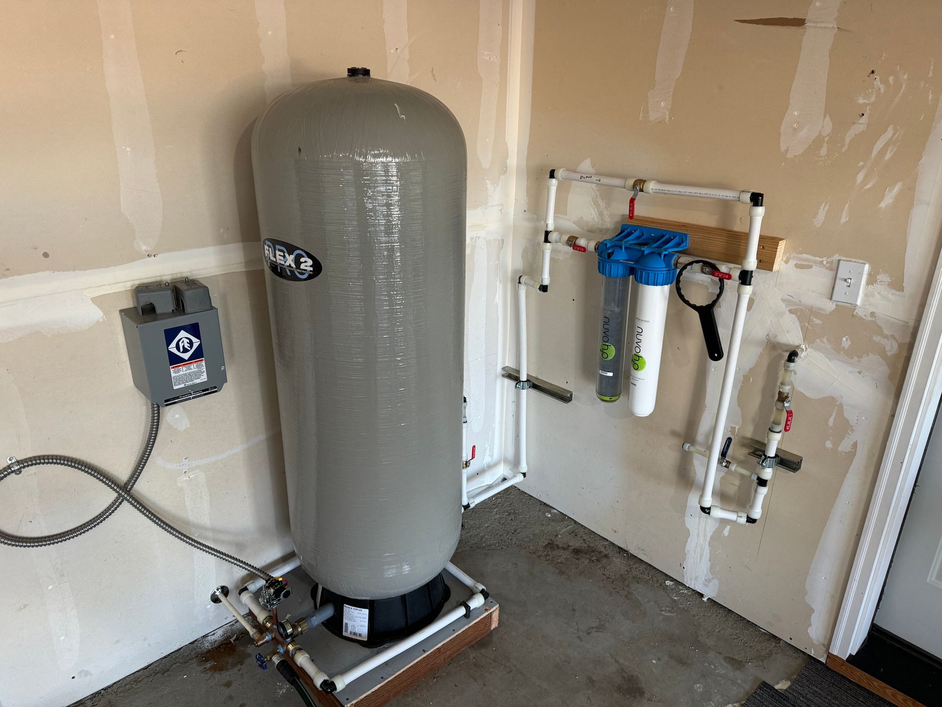 A water tank is sitting in a room next to a wall.