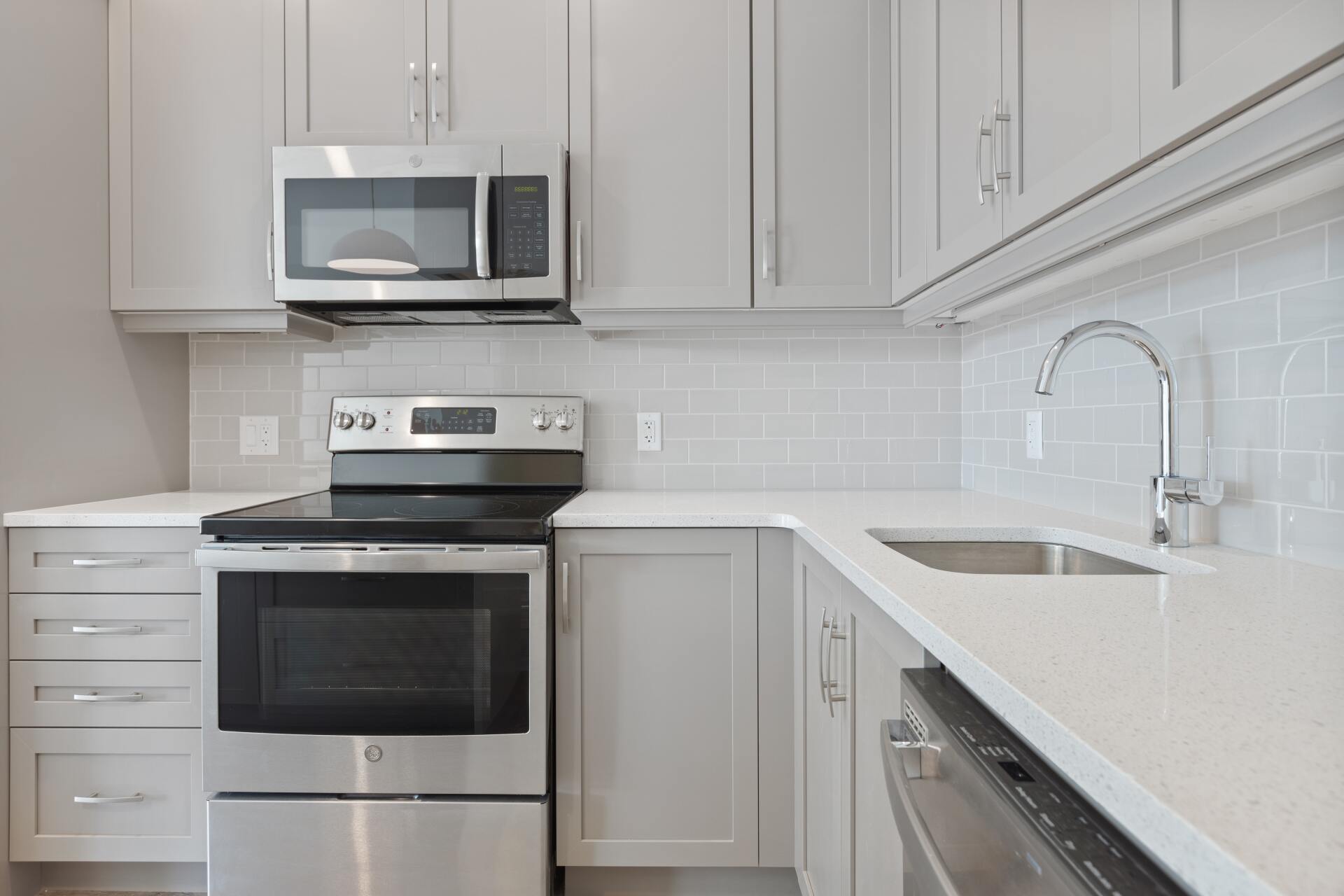 An elegant kitchen cabinet with a sleek built-in microwave positioned above a stylish stove.