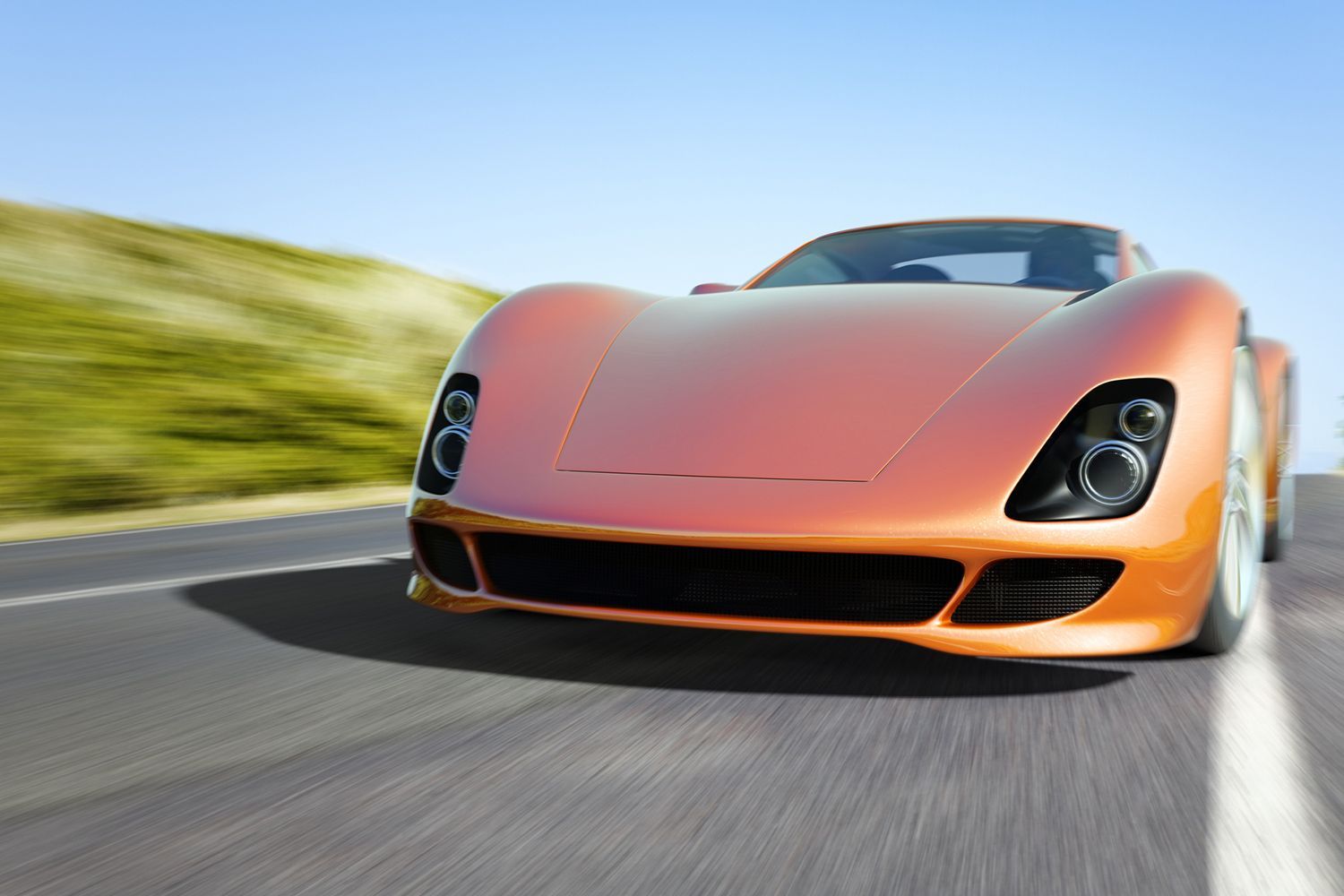 An orange sports car is driving down a road