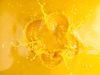 Liquido giallo che schizza verso l'alto, creando una forma simile a una corona.