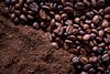 Chicchi di caffè e caffè macinato, primo piano; si nota il contrasto di consistenze e colori.