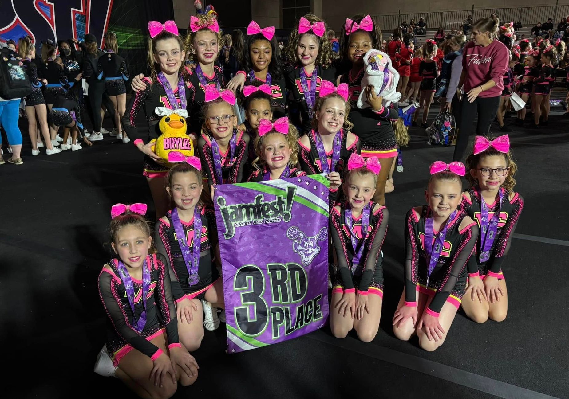 A group of cheerleaders holding a sign that says 3rd place