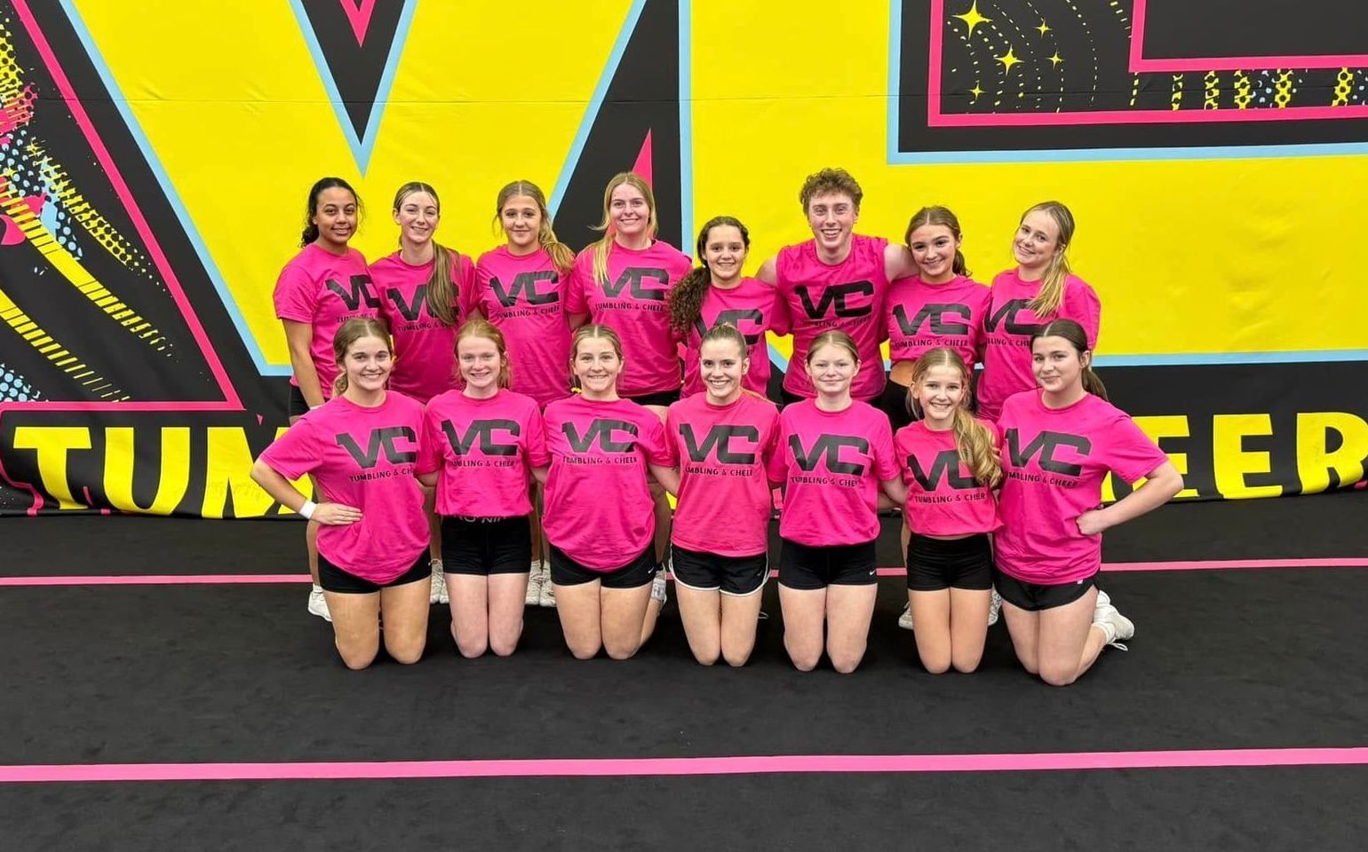 A group of cheerleaders are posing for a picture on a trampoline.