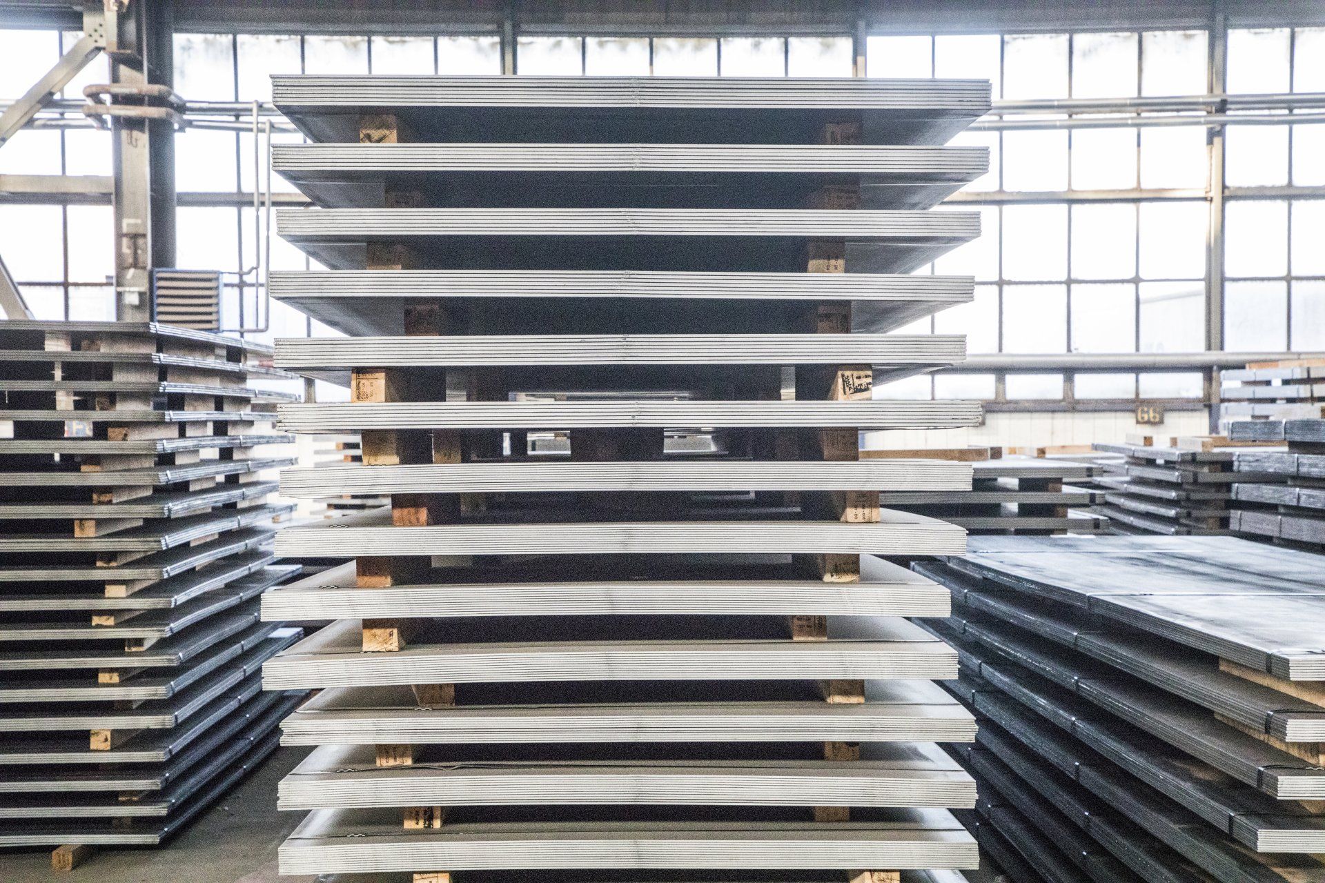 a warehouse filled with lots of steel plates stacked on top of each other .