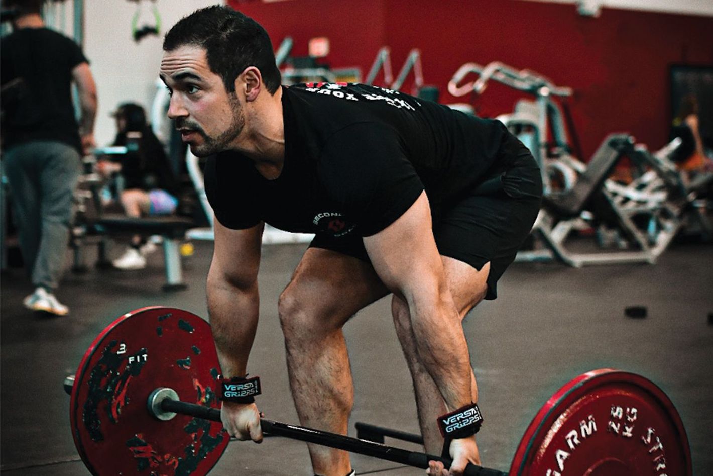 a man is lifting dumbbells in a gym .