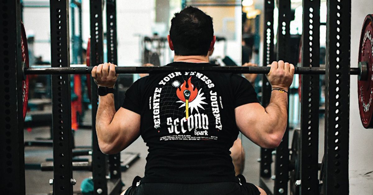 a man is lifting a dumbbell in a gym .