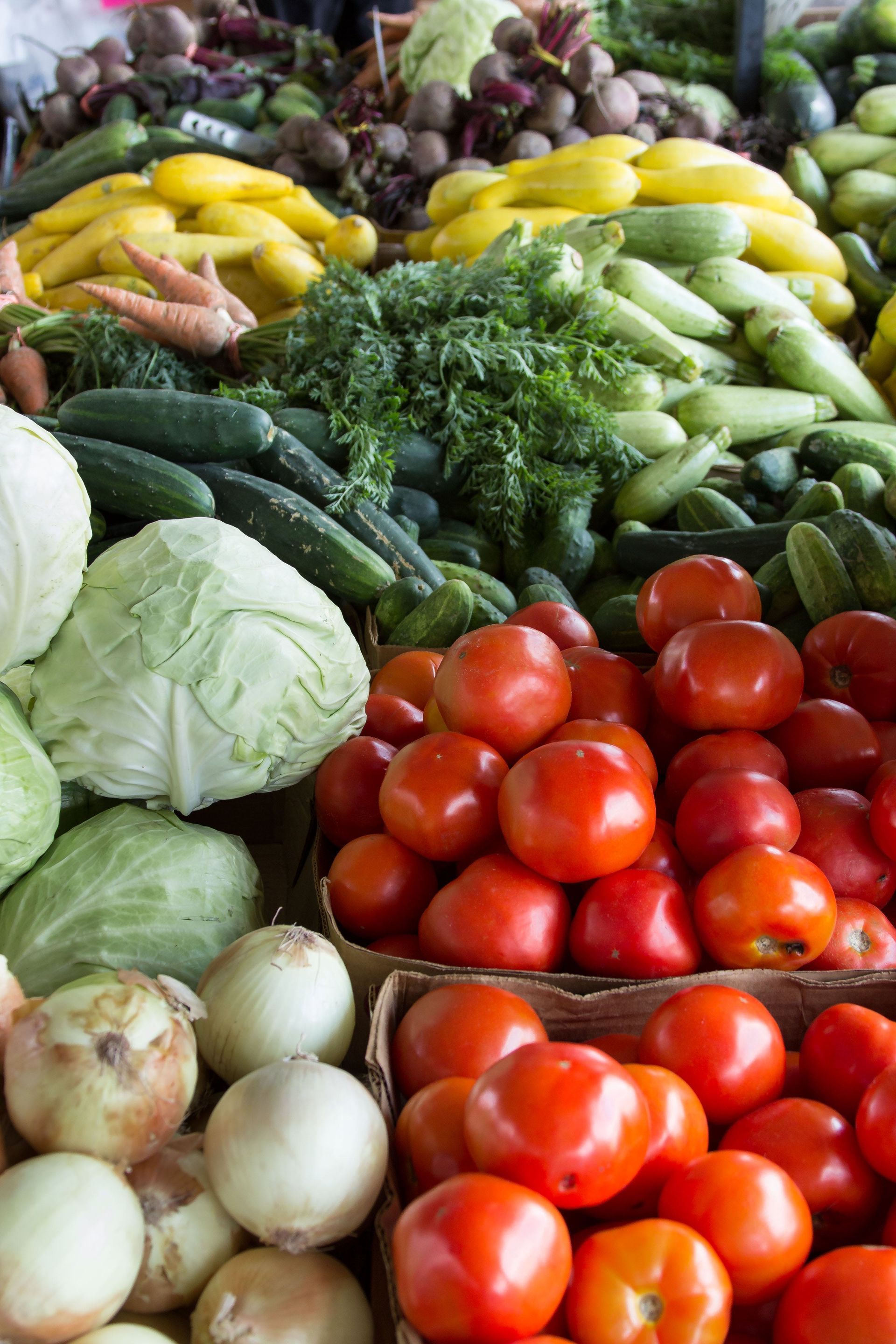 A variety of vegetables including tomatoes , cucumbers , cabbage , onions and peppers