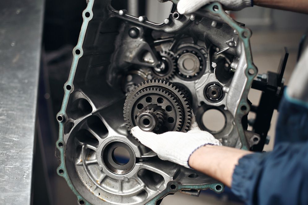 Mechanic’s Gloved Hands Inspecting Engine Gears — Fischer Automotive in Svensson Heights, QLD
