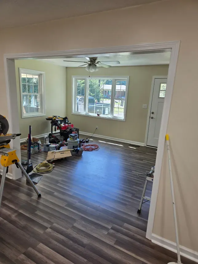 A living room with hardwood floors and a ceiling fan.