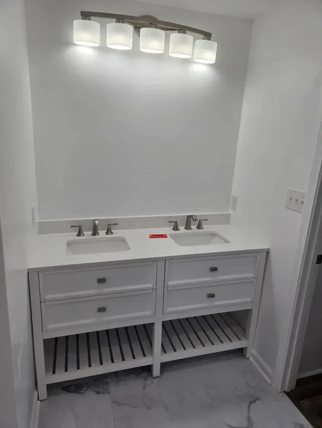 A bathroom with two sinks and a mirror.