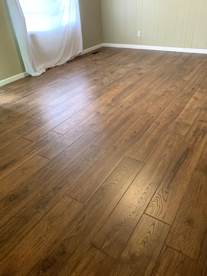 A living room with hardwood floors and a window.