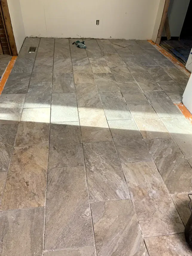 A room with a tiled floor and a white wall.