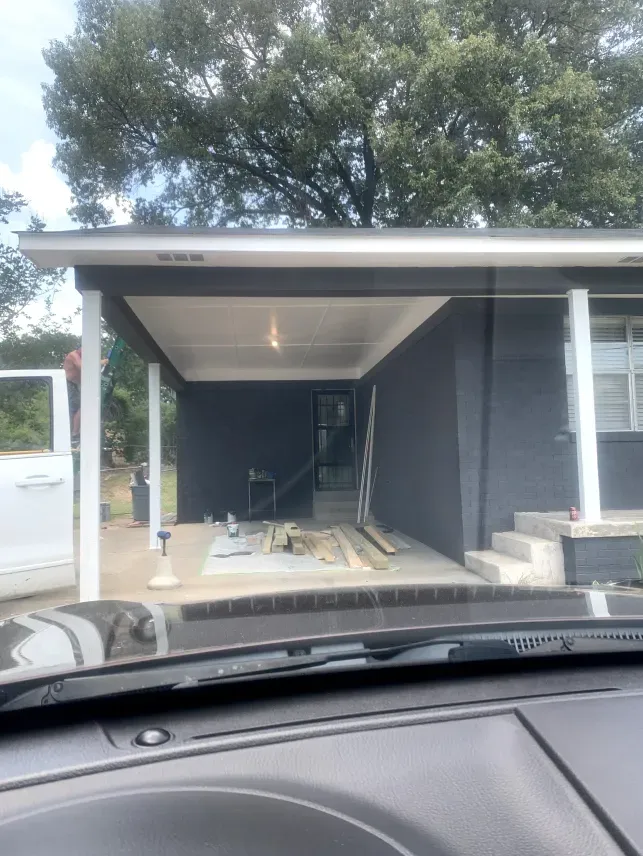 A car is parked in front of a house under construction