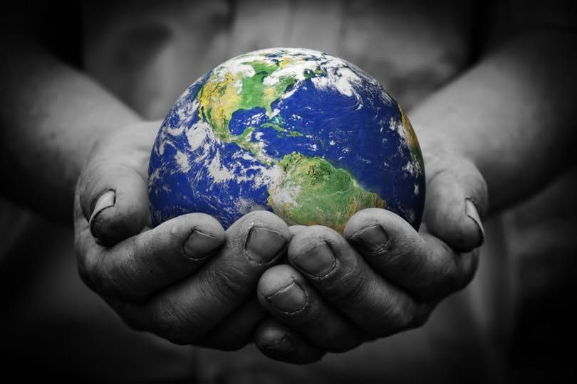 A person is holding a globe in their hands representing Cotswold Grange Country Parks sustainability