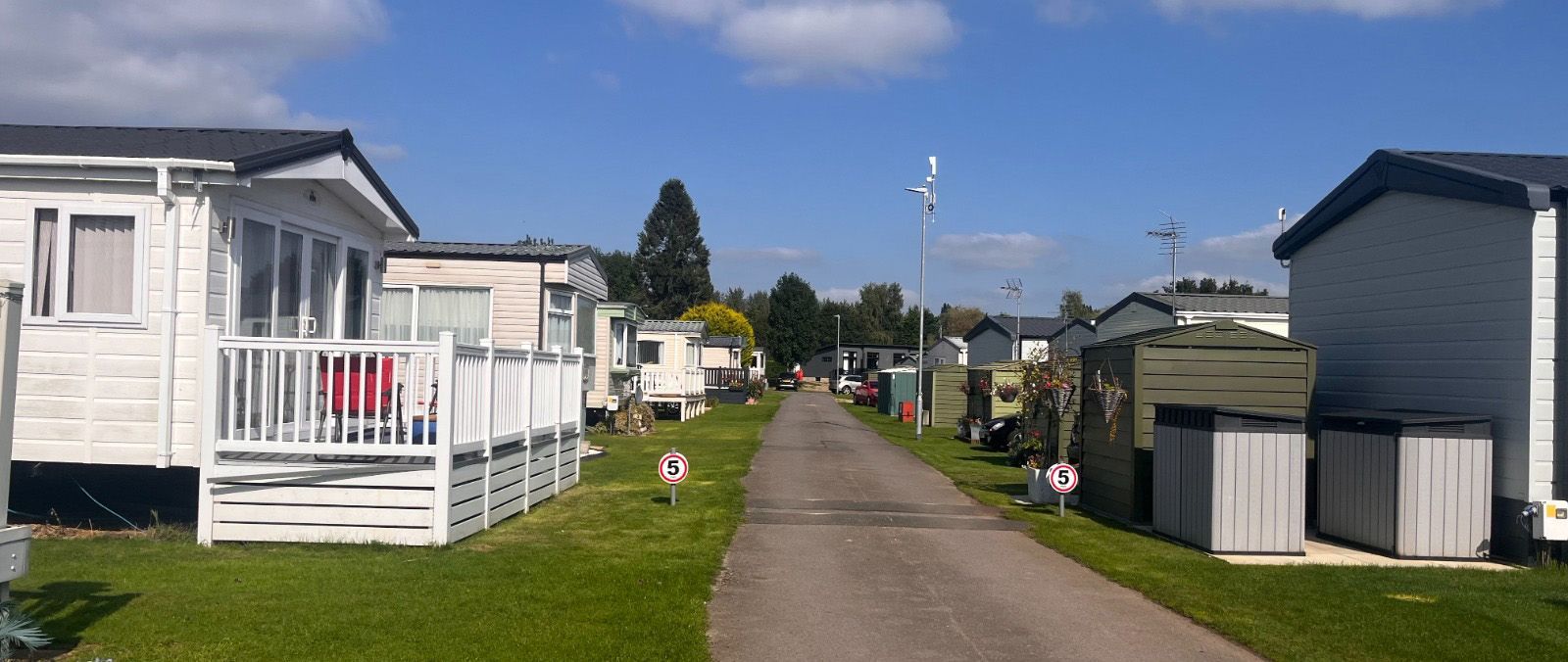 A row of mobile homes are lined up on the side of a road.