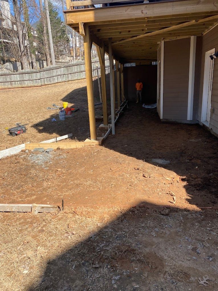A wooden deck is being built in the backyard of a house.
